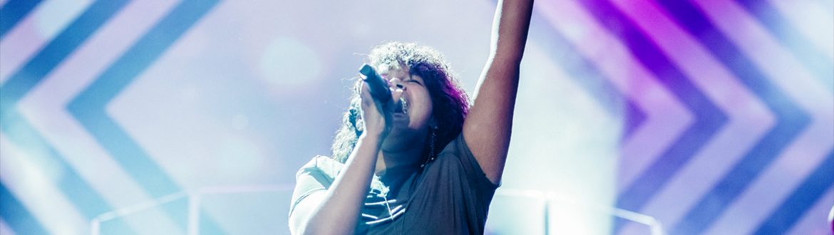 Woman singing on stage and raising arm