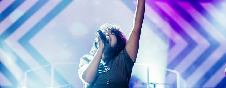 Woman singing on stage and raising arm