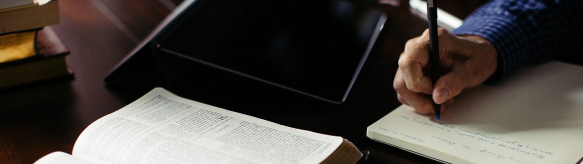 Pastor writing notes in book