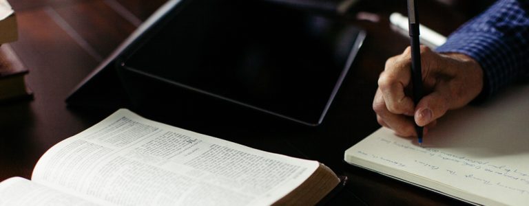 Pastor writing notes in book