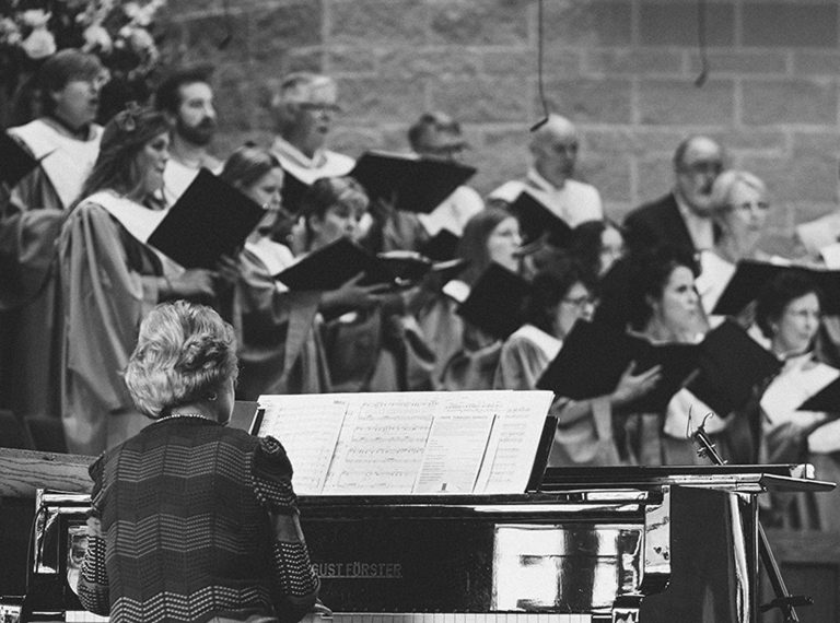 Woman playing piano with choir